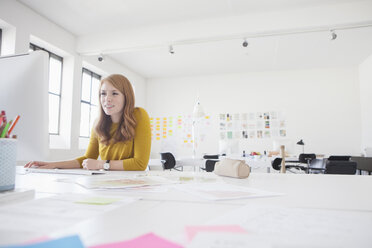 Junge Frau im Büro bei der Arbeit am Schreibtisch - RBF003943