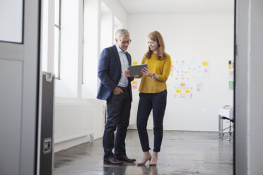 Businessman and coworker discussing project in office - RBF003950