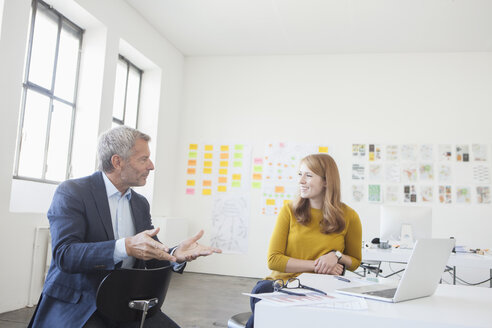 Geschäftsmann und Kollege diskutieren im Büro - RBF003965