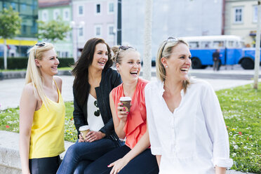 Vier junge Frauen lachen im Freien und drehen sich um - DAWF000462