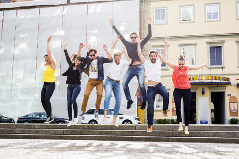 Enthusiastische Freunde springen von der Treppe, lizenzfreies Stockfoto