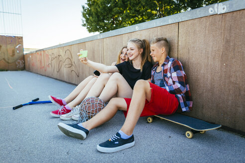 Drei Teenager machen im Freien ein Selfie - AIF000174