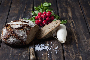 Krustenbrot, Brotmesser, rote Radieschen, Rettich und verstreute Salzkörner auf dunklem Holz - CSF026973