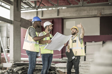 Bauarbeiter diskutieren auf der Baustelle über den Bauplan - ZEF007832