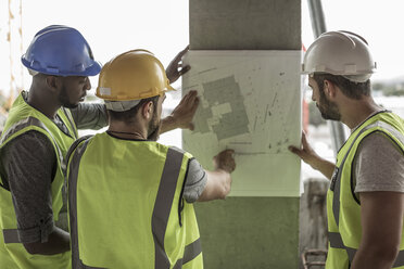 Bauarbeiter diskutieren auf der Baustelle über den Bauplan - ZEF007843