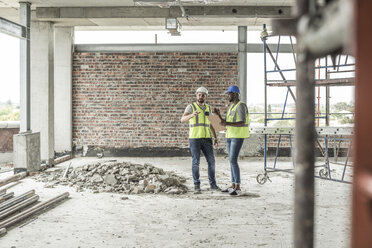 Bauarbeiter, die auf einer Baustelle diskutieren - ZEF007845