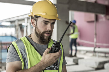 Bauarbeiter mit Walkie-Talkie auf einer Baustelle - ZEF007846