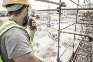 Construction worker with walkie-talkie in construction site - ZEF007858