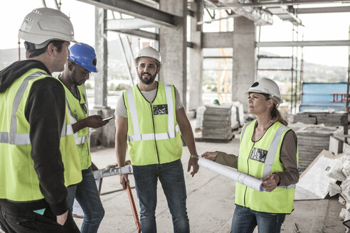 Frau in Arbeitsschutzkleidung und Bauarbeiter auf einer Baustelle - ZEF007859