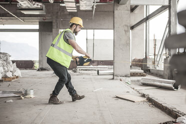 Construction worker using tape measure in construction site - ZEF007863