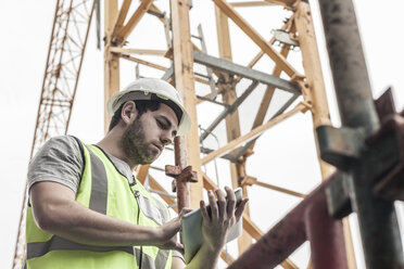 Bauarbeiter mit digitalem Tablet auf der Baustelle - ZEF007868