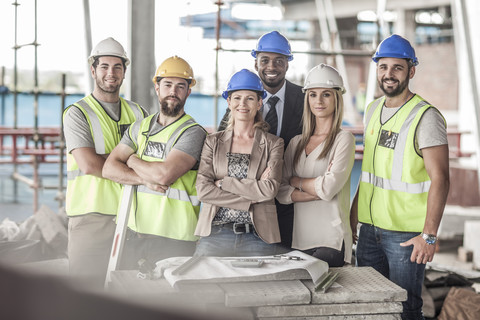 Porträt von zuversichtlichen Bauarbeitern und Führungskräften auf einer Baustelle, lizenzfreies Stockfoto