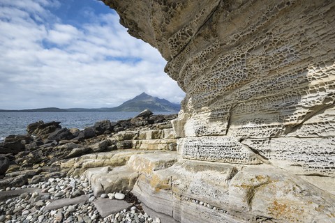 Vereinigtes Königreich, Schottland, Isle of Skye, Tafoni Felsformationen, Cuillin Hills im Hintergrund, lizenzfreies Stockfoto