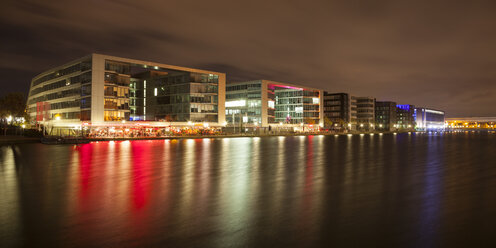 Germany, North Rhine-Westphalia, Duisburg, Inner harbour with office buildings and restaurants at night - WIF003083