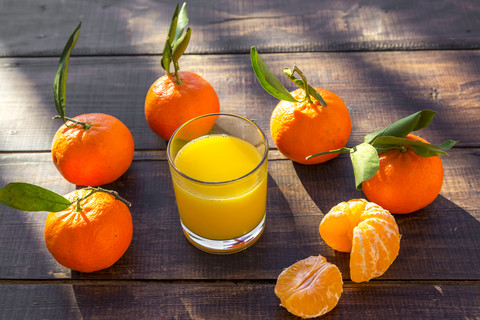 Tangarinen, Saft im Glas auf Holz, lizenzfreies Stockfoto