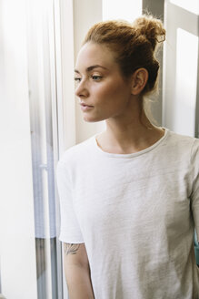 Junge Frau schaut aus dem Fenster - MFF002584