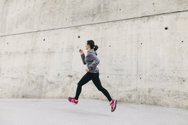 Woman runner in jogging outfit running on a street. Woman