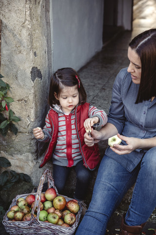 Mutter und ihre kleine Tochter mit frisch geernteten Bio-Äpfeln, lizenzfreies Stockfoto