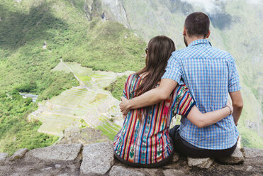 Peru, couple sitting and enjoying the views of Machu Picchu citadel - GEMF000622