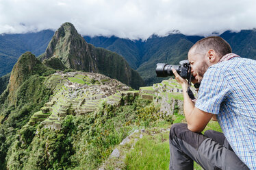 Peru, Mann fotografiert die Zitadelle von Machu Picchu und den Berg Huayna Picchu - GEMF000624