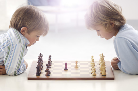 Zwei kleine Jungen spielen Schach, lizenzfreies Stockfoto