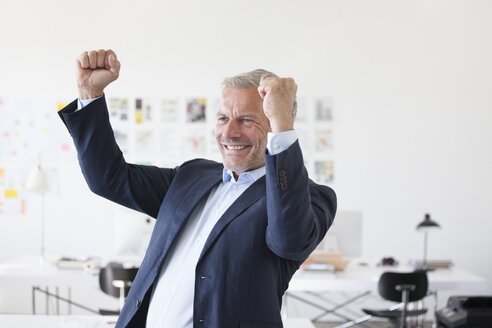 Geschäftsmann jubelt im Büro - RBF003997