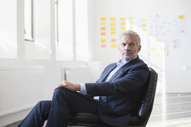 Geschäftsmann sitzt auf einem Stuhl im Büro - RBF004003