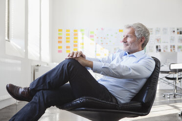 Businessman sitting in chair in office - RBF004005