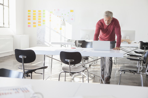 Businessman using laptop in office stock photo