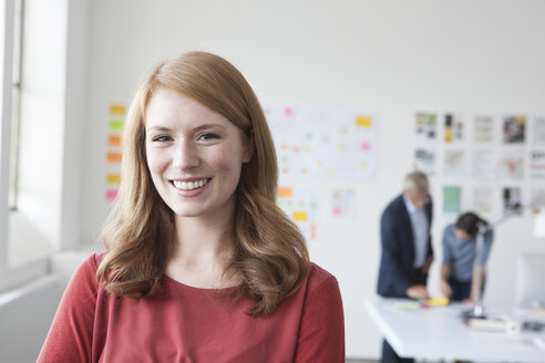 Portrait of smiling young woman in office - RBF004021