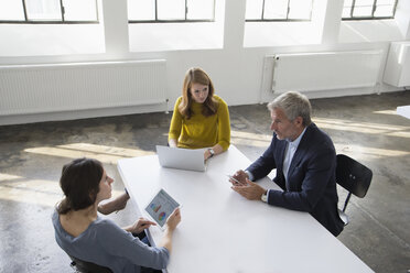 Businessman and two women in conference room having a meeting - RBF004043