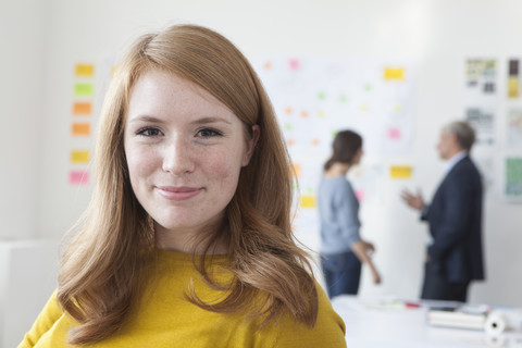 Porträt einer lächelnden jungen Frau im Büro, lizenzfreies Stockfoto