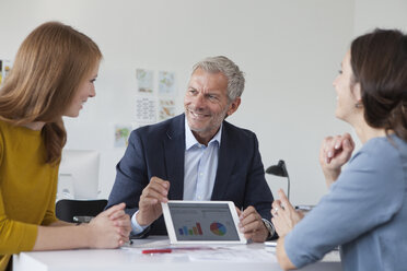 Geschäftsmann und zwei Frauen im Büro bei einem Treffen - RBF004057