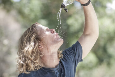 Junger Mann gießt Wasser über sein Gesicht - ZEF007927
