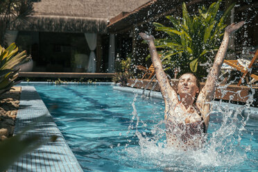 Brasilien, Porto Seguro, Frau spritzt im Schwimmbad mit Wasser - MFF002607