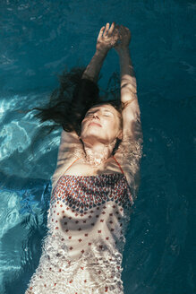 Woman floating on water of a swimming pool - MFF002608