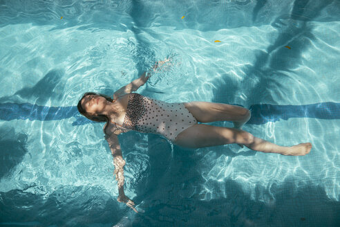 Woman floating on water of a swimming pool - MFF002609