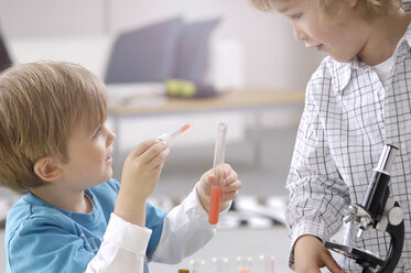 Zwei kleine Jungen spielen mit Utensilien eines chemischen Labors - GUFF000236
