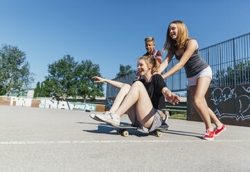 Three playful teenage friends with skateboard - AIF000260