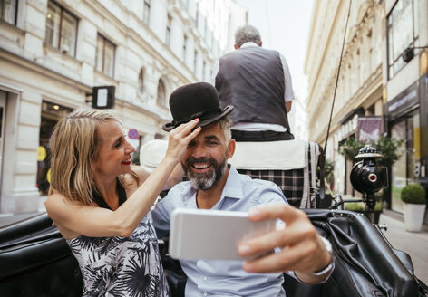 Austria, Vienna, couple having fun on sightseeing tour in a fiaker - AIF000279