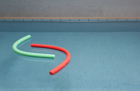 Aqua noodles floating on water of indoor swimming pool stock photo