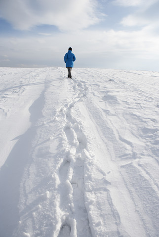 Frau geht im Schnee, lizenzfreies Stockfoto