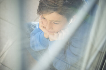 Boy with head in his hands looking through window - SIPF000032