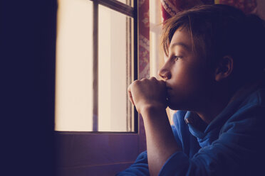 Pensive boy looking through window - SIPF000034