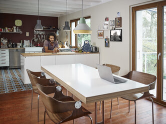 Young man in open plan kitchen - RHF001229