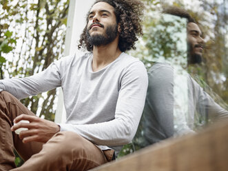 Young man relaxing on terrace - RHF001254