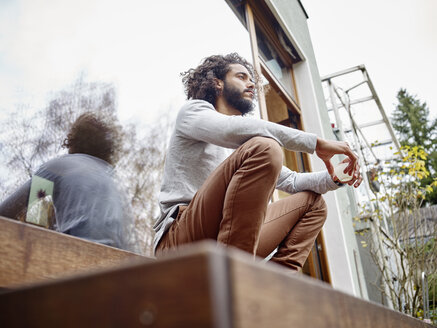 Young man relaxing on terrace - RHF001256