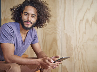 Porträt eines jungen Mannes mit digitalem Tablet - RHF001270