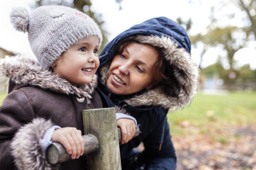 Portrait of happy little girl with her mother on a playground in autumn - MGOF001244