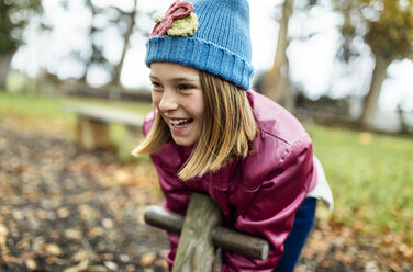 Porträt eines glücklichen Mädchens auf einem Spielplatz im Herbst - MGOF001249